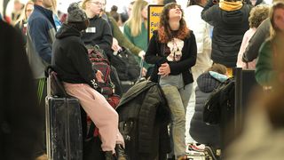     Ella Silverstein searches for a flight while waiting in line to book a flight outside the Southwest Airlines ticket counter at Denver International Airport in Denver, Colorado on Thursday, Dec. 22.